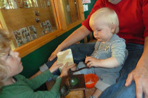 das Kleinkind dreht die Kaffeemühle